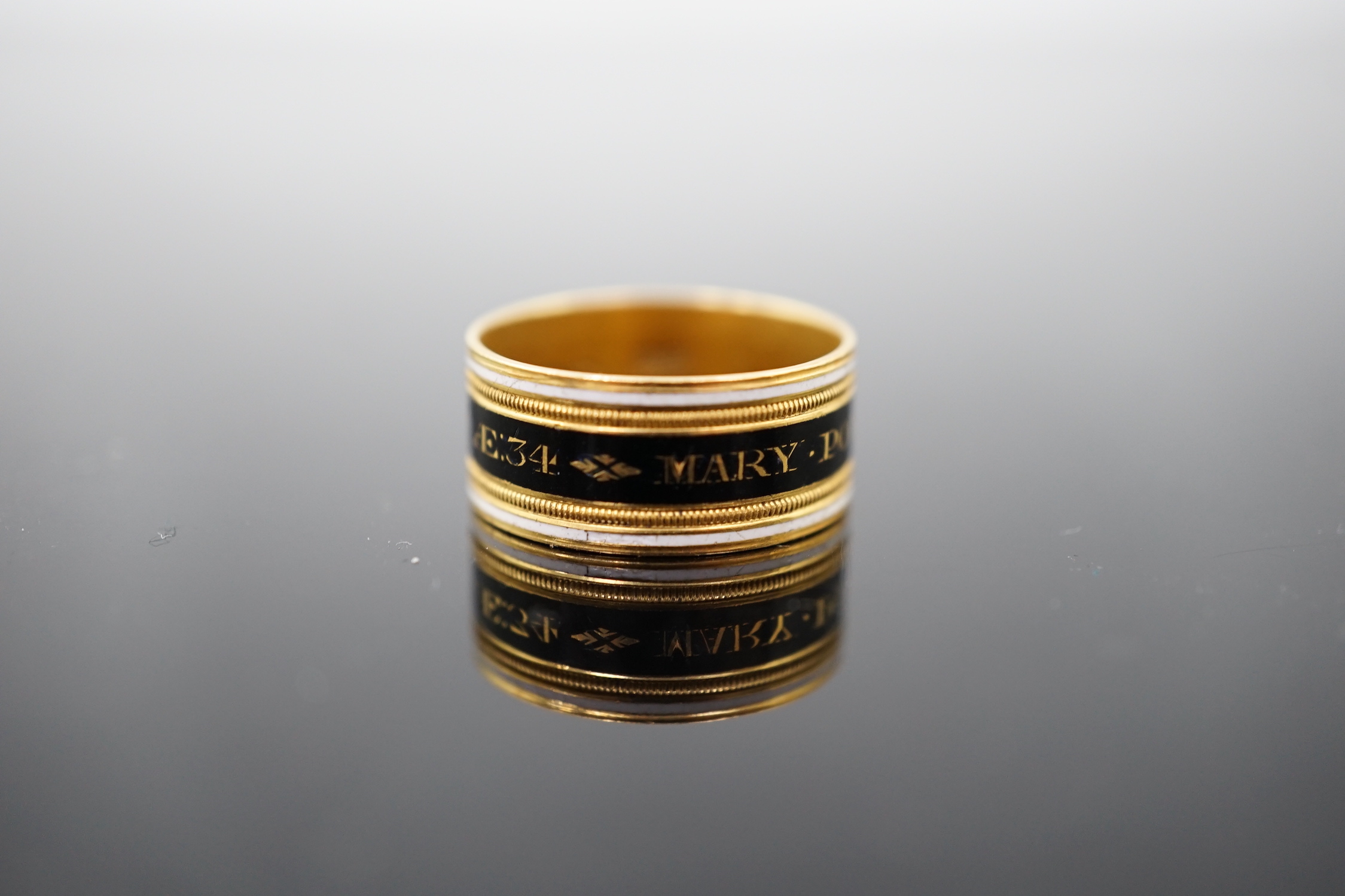 A George III 22ct gold and two colour enamel mourning band, inscribed 'Mary Powell OB. 12 Mar, 1809'